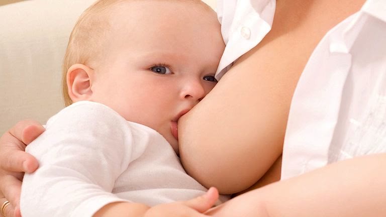 Madre amamantando después de un aumento de pecho con prótesis