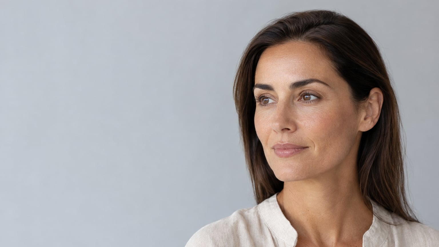 Retrato ilustrativo de una mujer adulta con pómulos y contorno de las mejillas naturales; imagen generada, no caso clínico